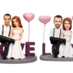 Romantic wedding cake toppers: a couple in formal attire sitting with pink heart balloons and the word LOVE on a base.