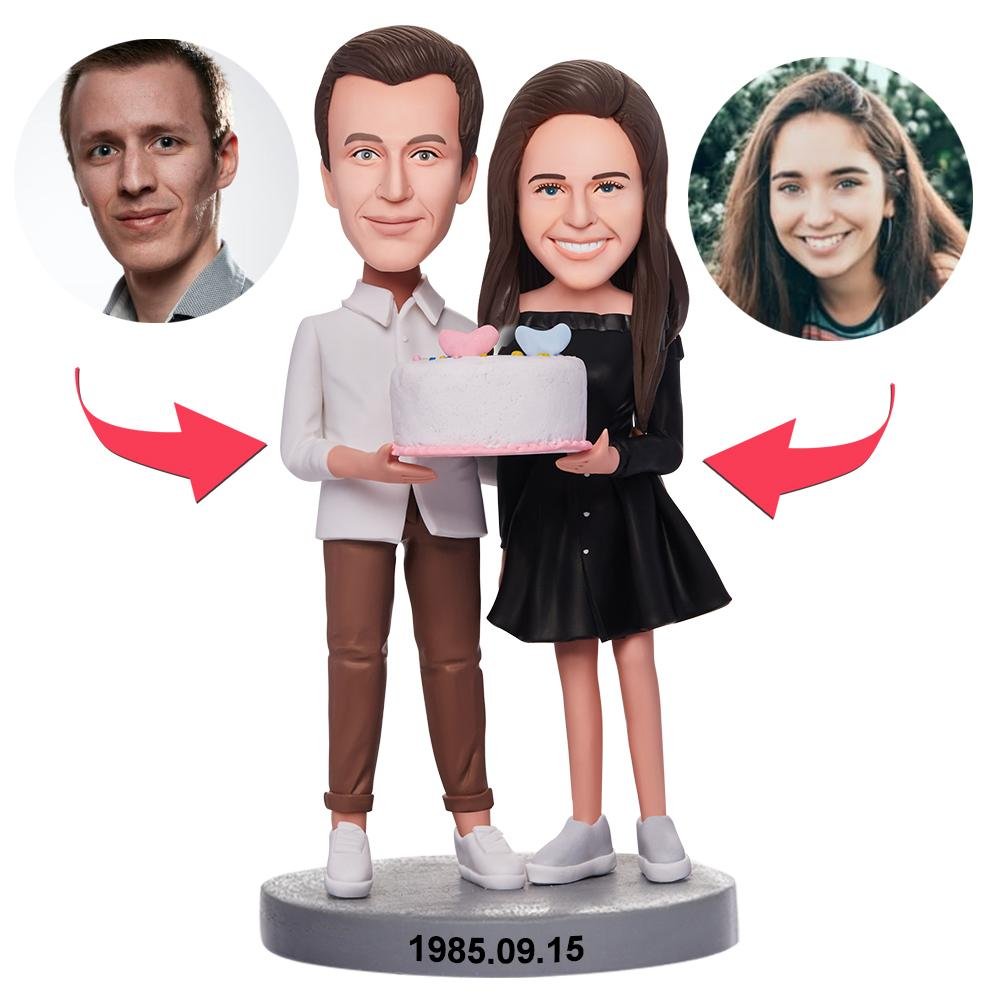 Custom couple bobblehead holding a birthday cake created from customer photos