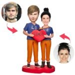Custom couple bobblehead holding an I Love You heart created from customer photos
