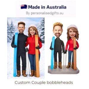 Custom couple bobblehead figurines in winter skiing outfits holding skis, with snowy backdrop and 'Made in Australia' branding at top.
