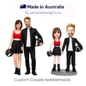 Custom couple bobbleheads: a man and woman in black outfits with helmets, standing side by side holding hands with a motorcycle vibe.