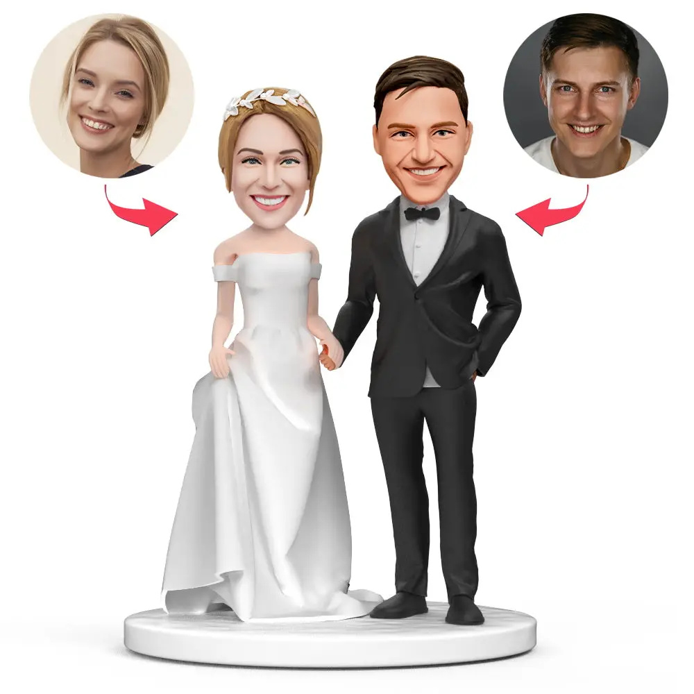 Cartoon wedding cake topper showing a bride in a white gown and groom in a black tuxedo on a round base, with two circular insets of real faces connected by arrows.