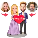 Cartoon couple wedding figurine holding a red heart that says 'Marry Me', with two circular headshots shown on either side.