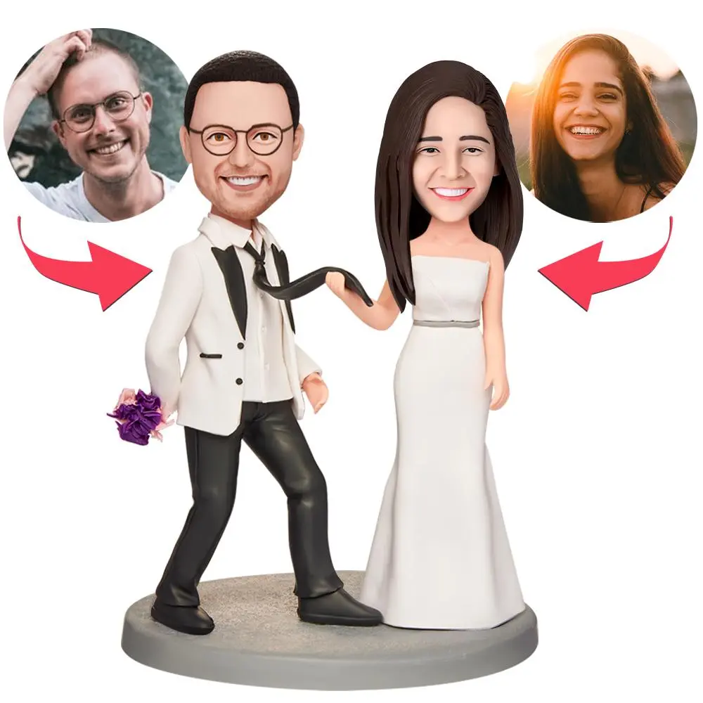 Wedding cake topper with a cartoon bride and groom; each head features a circular photo of the real couple, with arrows pointing to the photos.