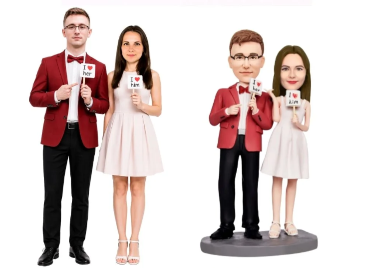 Two pairs of wedding figurines: a man and woman stand holding signs that say 'I love her' and 'I love him'. On the right, a similar couple stands on a pedestal with matching signs.