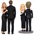 Left: a smiling woman in a black formal dress and a man in a black suit stand with their backs turned to the camera; right: two cartoon bobblehead figures in black attire hug on a small pedestal.