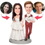 Custom wedding cake topper with bride and groom figurines; their heads are replaced by the couple's photos, and the groom holds a heart reading 'Just married'