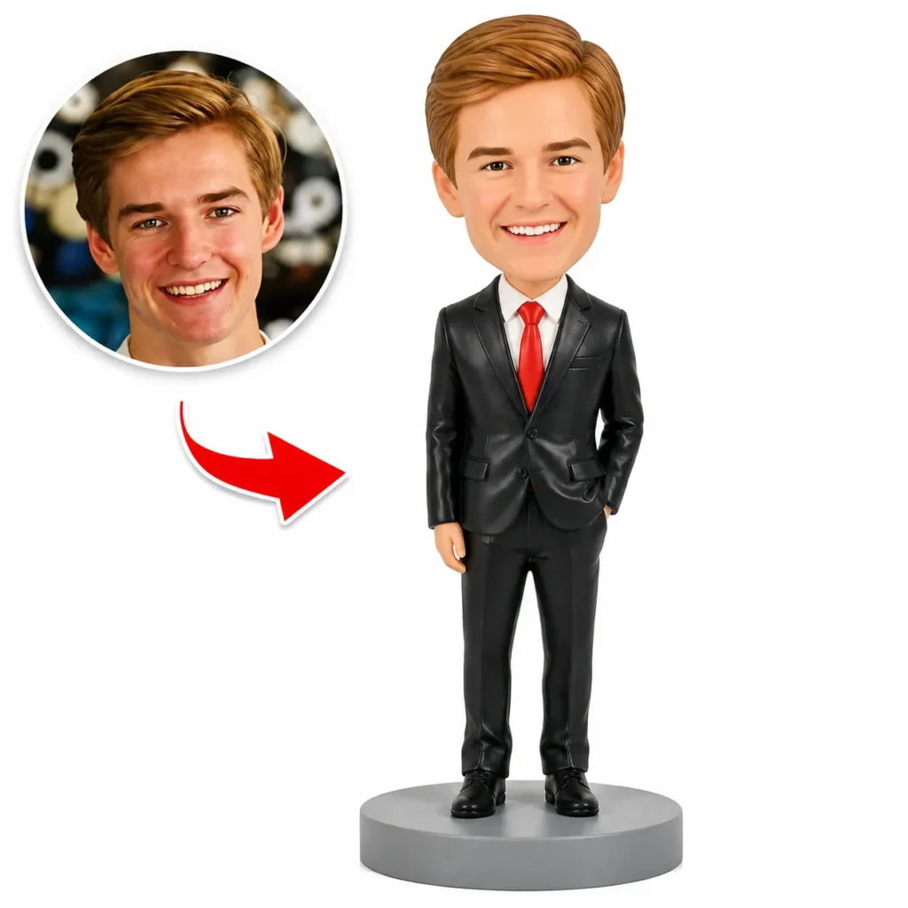 Custom bobblehead of a businessman in a black suit and red tie, with the original photo shown in a circle to the left and an arrow pointing to the figure.