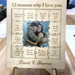 Wooden '12 reasons why I love you' love puzzle frame featuring a photo of a couple in the center and handwritten-style reasons around the edges (gift keepsake).