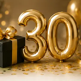 Gold '30' balloons with a black gift box wrapped in gold ribbon, celebrating a 30th birthday or anniversary.