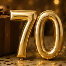 Gold foil balloons shaped as '70' with a wrapped gift and confetti for a 70th anniversary celebration.