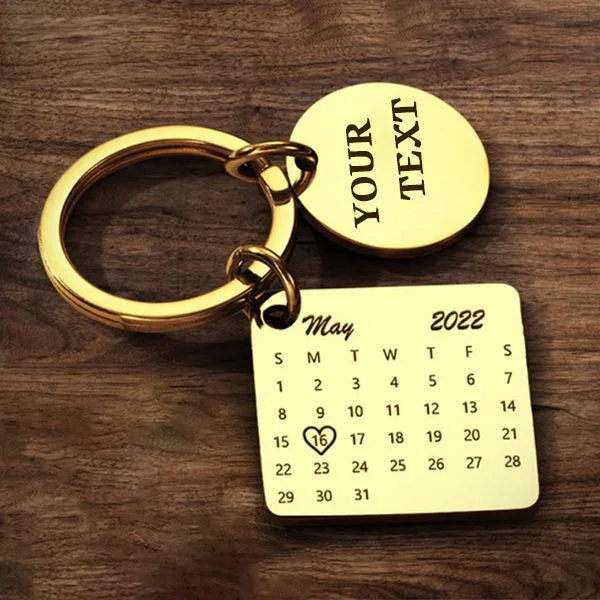 Gold keychain with a circular tag reading YOUR TEXT and a May 2022 calendar pendant, the 16th circled with a heart.