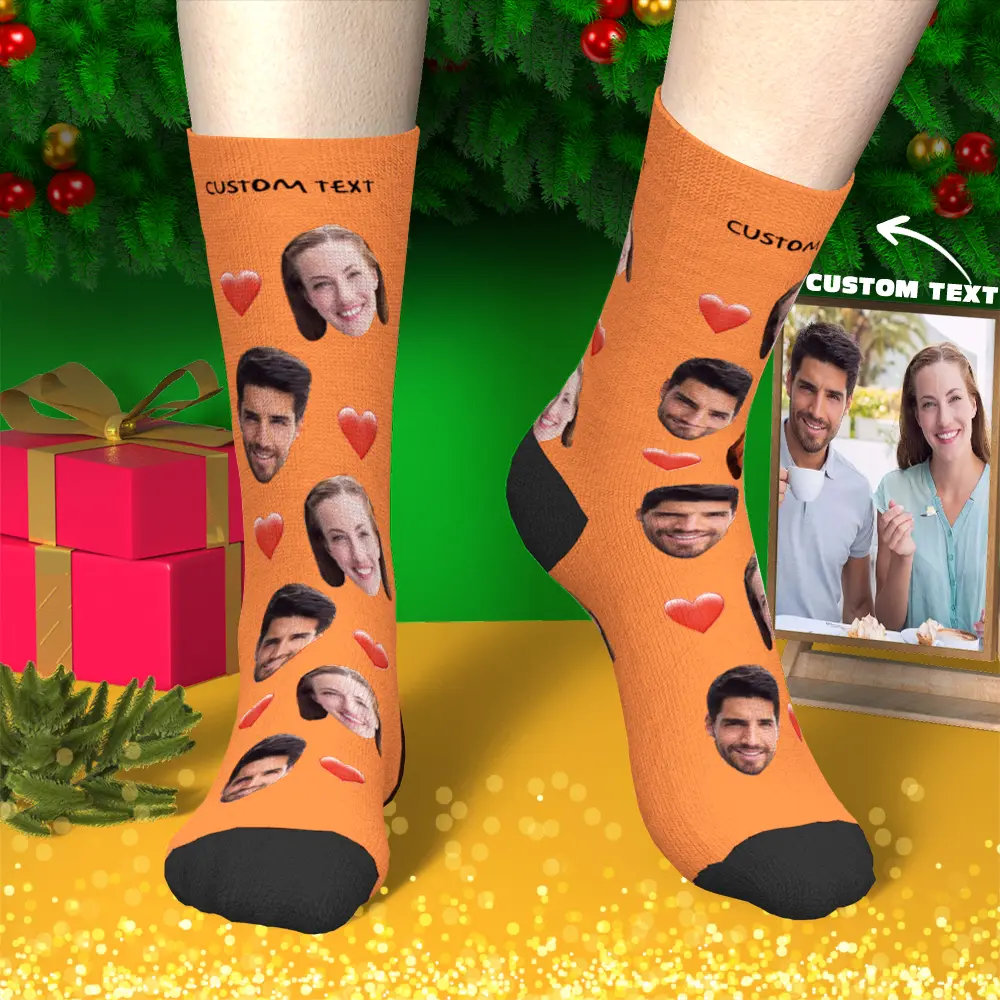 Personalized orange socks covered with cutout faces and red hearts, worn in a festive Christmas scene with gifts and a 'Custom Text' photo frame nearby.
