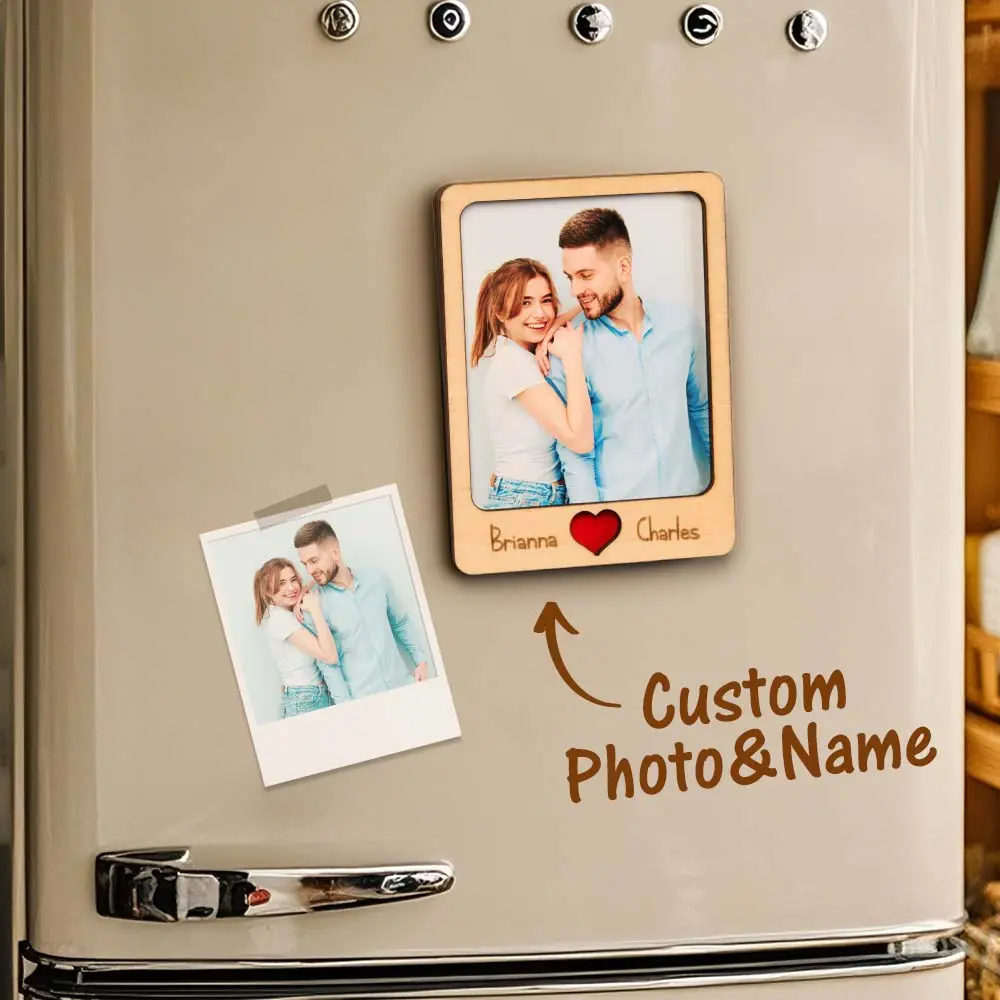 Fridge door with a wooden photo frame of a smiling couple, a taped Polaroid photo, and 'Custom Photo & Name' with an arrow and heart icon between names.