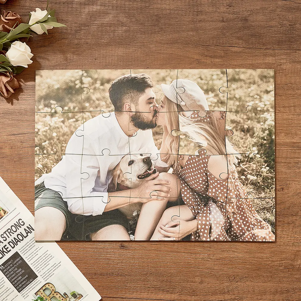 Couple kissing outdoors with their dog, assembled from puzzle pieces on a wooden table