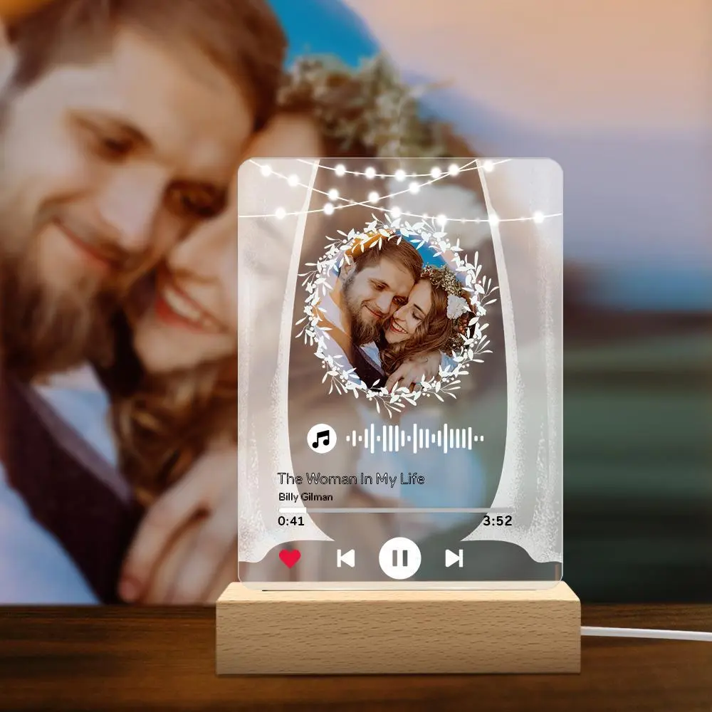 Decorative glass music plaque with a couple's photo in a floral wreath, string lights, and a playback bar on a wooden base (romantic keepsake).
