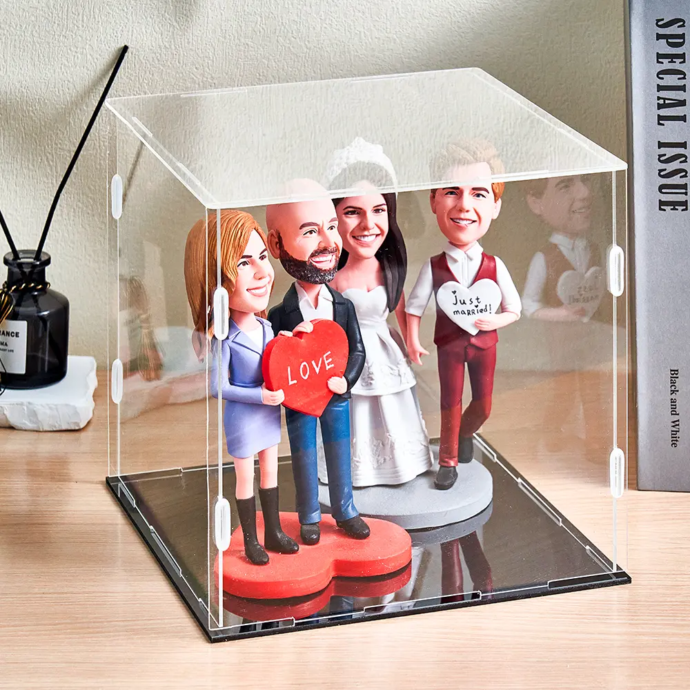 Wedding bobblehead figurines inside a clear display case; bride and groom with friends, groom holding a red 'LOVE' heart.
