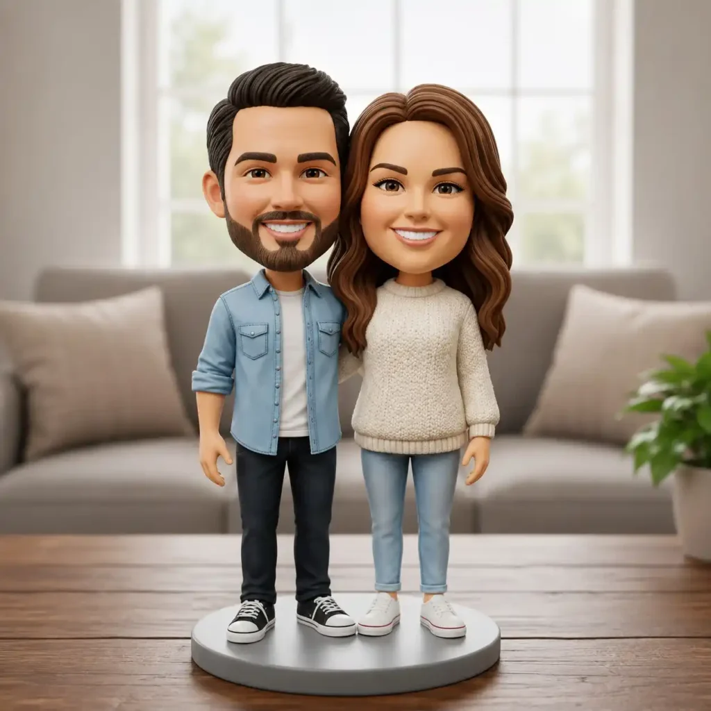 Two cartoon-style couple bobblehead figures stand arm in arm on a round display base in a bright living room.