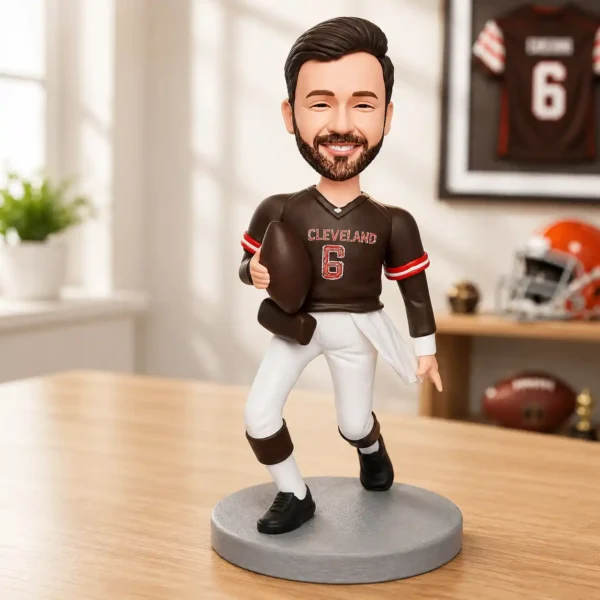Bobblehead figure of a Cleveland Browns player in a brown jersey #6, holding a football on a gray pedestal.