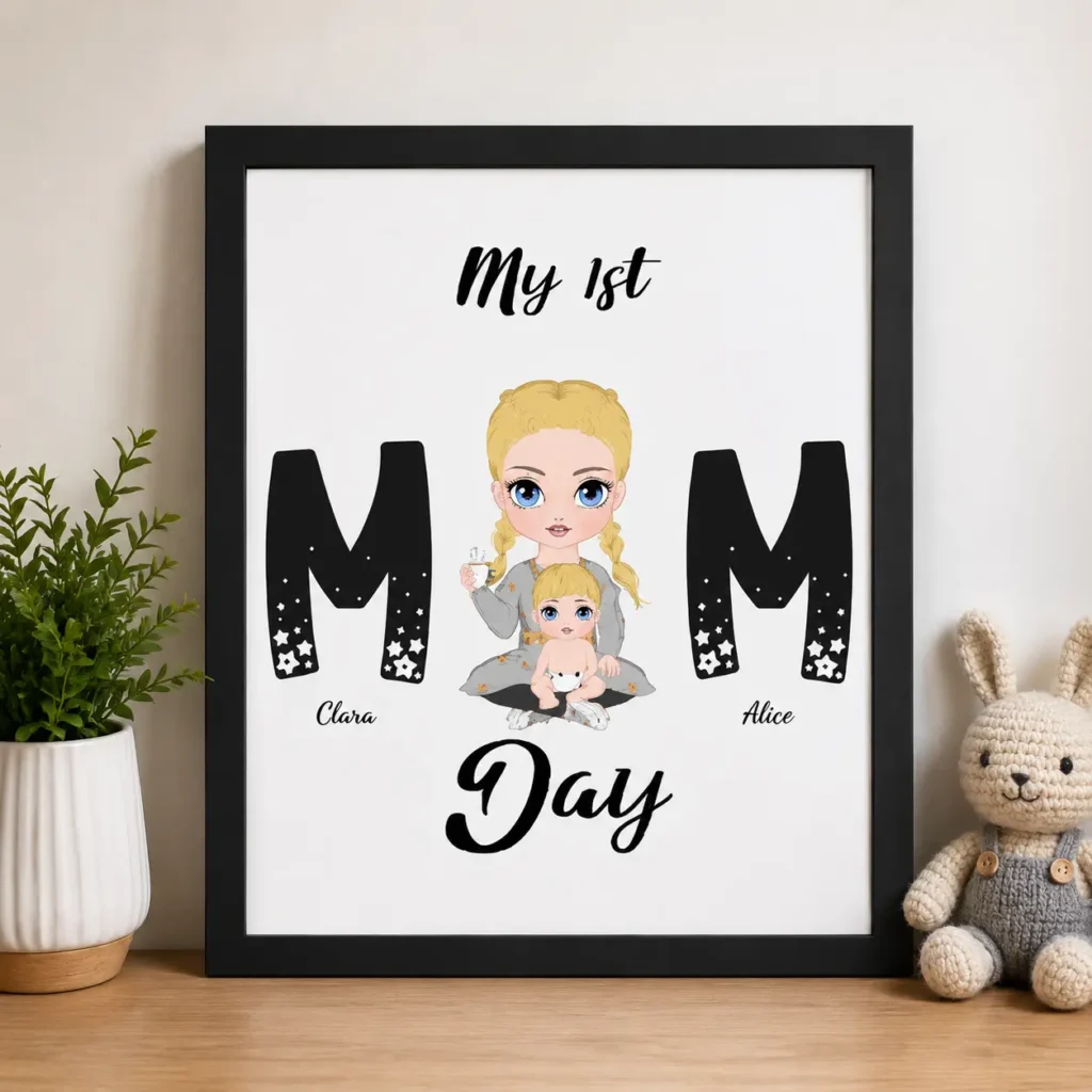 Framed print with two large black M letters on either side of a cartoon blonde mom holding a baby; top text says 'My 1st', bottom says 'Day' with the names Clara and Alice under each M.