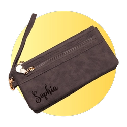 Brown zippered clutch with a wrist strap and 'Sophia' monogram on a yellow circular background.