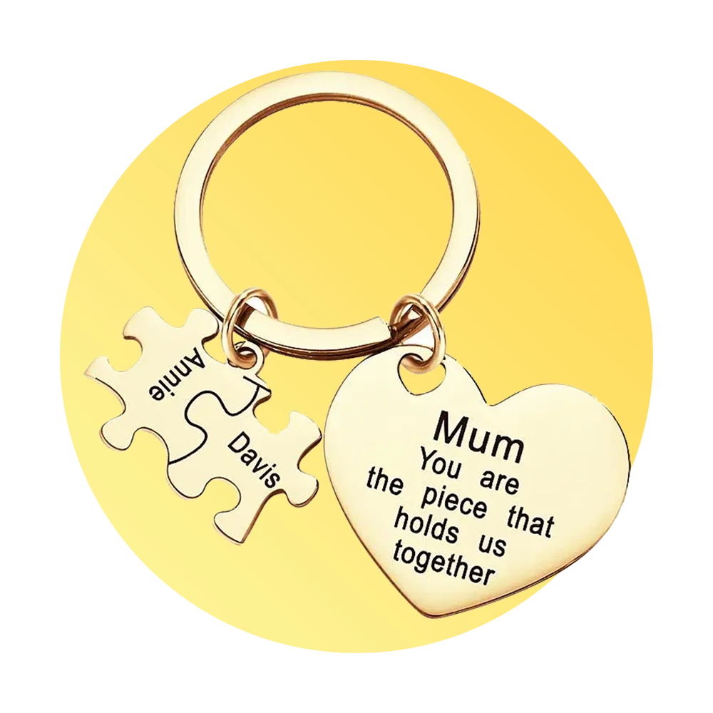 Gold heart keychain with the message 'Mum you are the piece that holds us together' and two puzzle-piece charms labeled Davis and Annie on a yellow background.