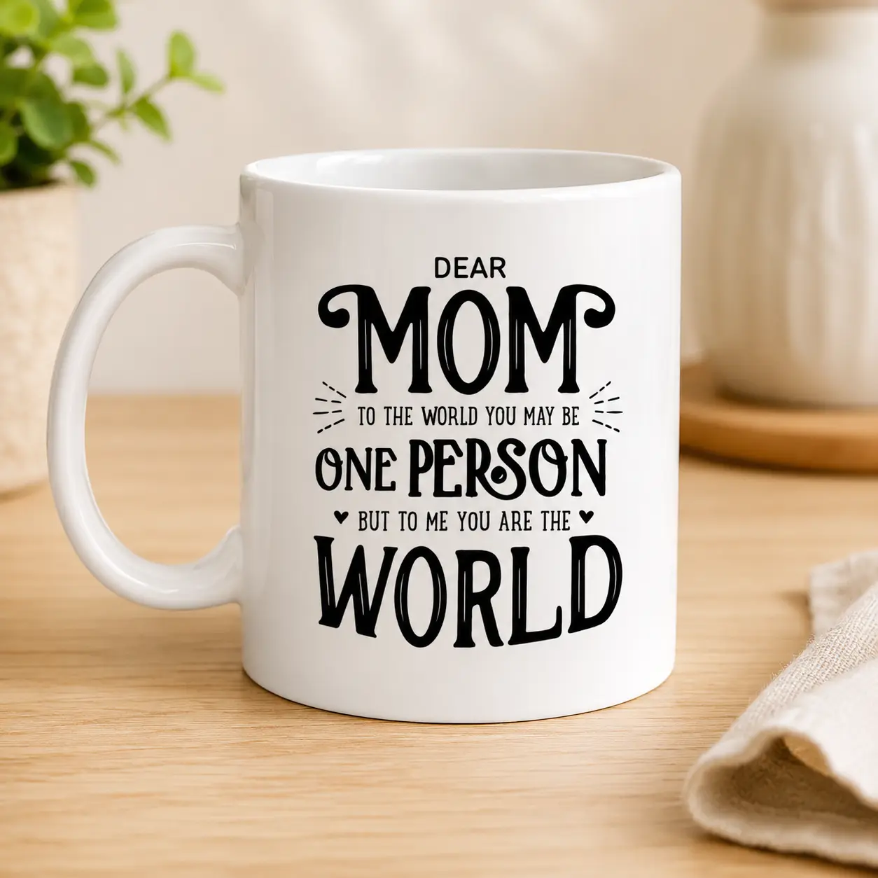 Mug - Personalized Gifts For All Occasions Gift Supplier White ceramic mug with a black handwritten-style message: 'Dear Mom, to the world you may be one person, but to me you are the world' featuring small hearts and decorative lines.