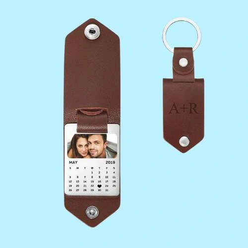 Brown leather calendar watch with a photo window and a detachable May 2019 calendar, paired with a matching brown leather keychain on a blue background.