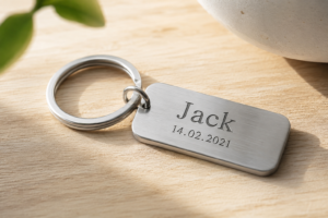 Close-up of a personalised engraved metal keyring with a name and date
